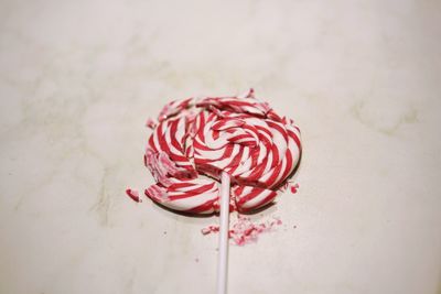 Close-up of broken lollipop on white table