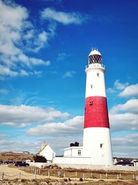 Lighthouse by sea against sky