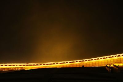 Low angle view of illuminated bridge against sky at night