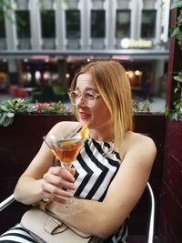 Portrait of a woman drinking glass in restaurant
