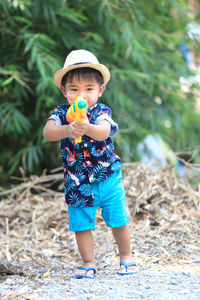 Full length of cute boy wearing hat on field