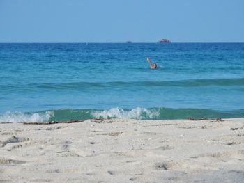 Distant male tourist swimming in the sea