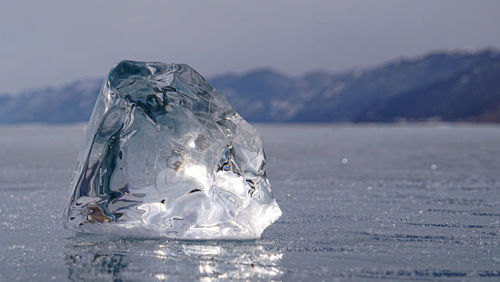 Close-up of ice on mountain against sky