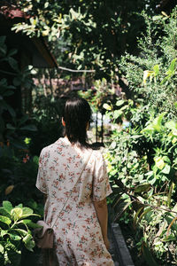 Rear view of woman standing by plants
