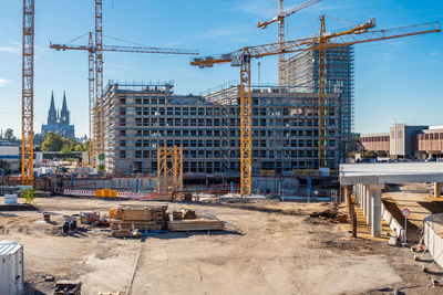 Construction site by buildings against sky