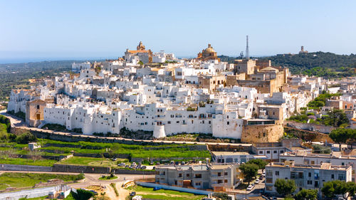 High angle view of townscape by sea against clear sky