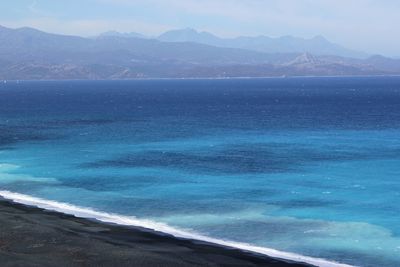 Scenic view of sea and mountains against sky
