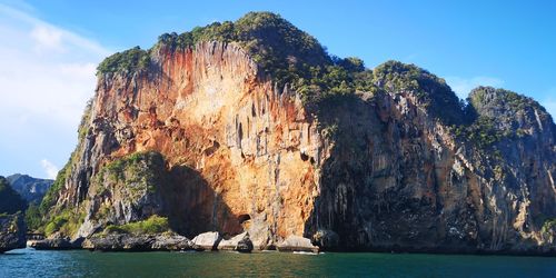 Panoramic view of rock formation in sea against sky