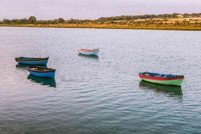 Boat moored in lake against sky