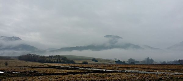 Scenic view of mountains against cloudy sky