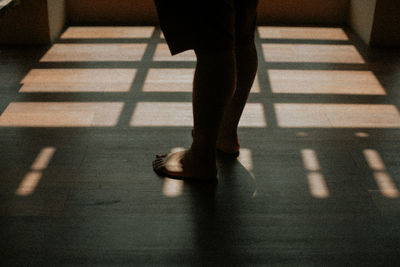 Low section of woman walking on tiled floor