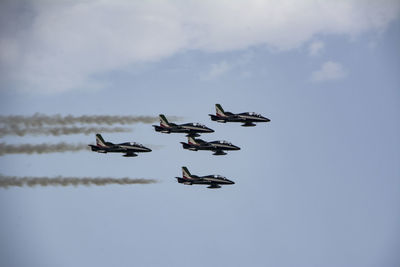 Low angle view of birds flying against sky