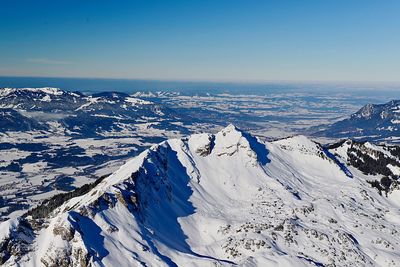 Scenic view of snowcapped mountains against blue sky