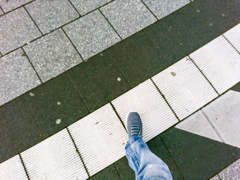 Low section of person standing on tiled floor