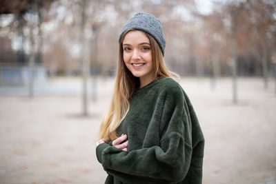 Portrait of a smiling young woman standing in snow