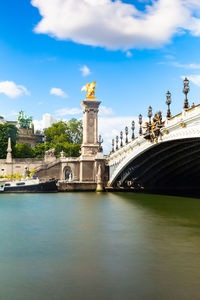 View of bridge over river against cloudy sky