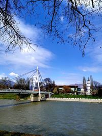 Bridge over river against sky in city