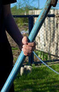 Cropped image of man holding hands on railing