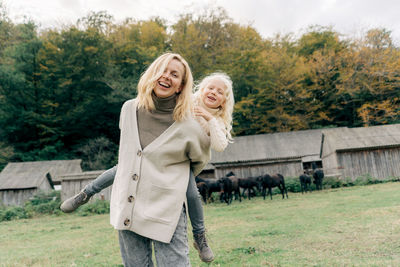 Mom and daughter have fun and play walking on a farm in the countryside.
