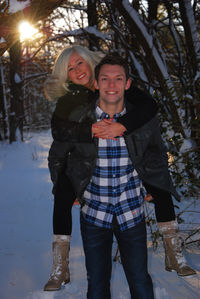 Portrait of happy friends standing in snow
