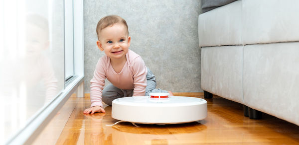 Portrait of cute boy sitting on floor at home