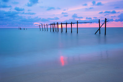 Pier on sea against sky during sunset