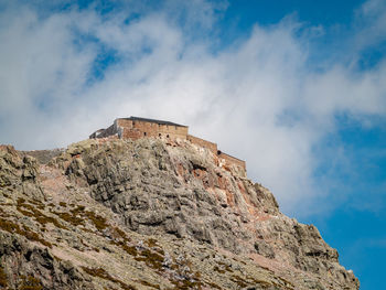 Low angle view of old building against cloudy sky