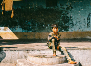 Full length of boy sitting outdoors