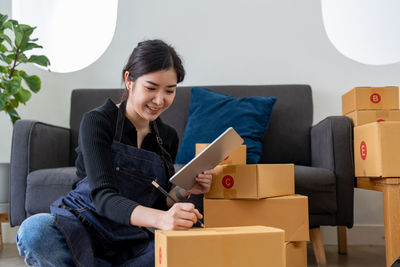 Portrait of young woman sitting on sofa at home