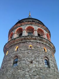 Low angle view of old building against clear blue sky