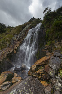 Scenic view of waterfall against rocks in retezat mountains 