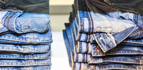 A pile of bluish shirts on a shelf