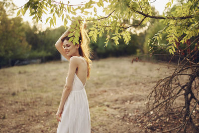 Midsection of woman standing by tree