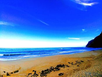 Scenic view of beach against blue sky