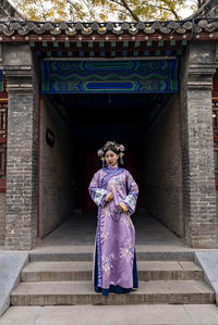 Portrait of woman wearing kimono standing on steps