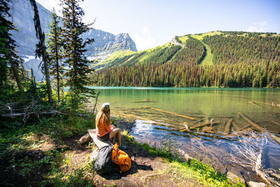 Hiker sitting at rawson lake looking towards sarrail ridge in rockies