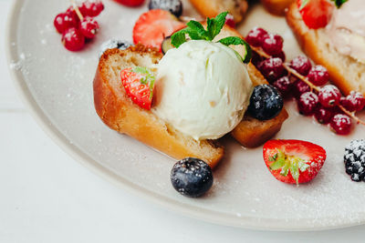 Close-up of ice cream with fruits and breads in plate on table