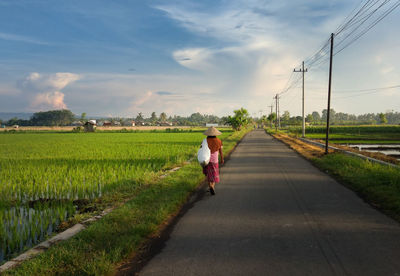 A woman going to work at the farm in the morning.