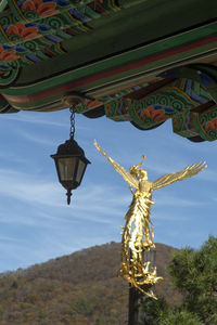 Low angle view of angel sculpture hanging at temple