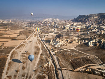 Aerial view of hot air balloon over landscape against sky