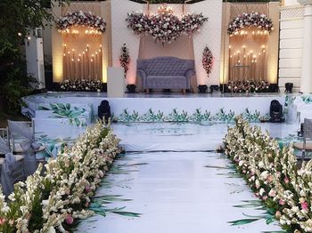 View of illuminated flowering plants by building