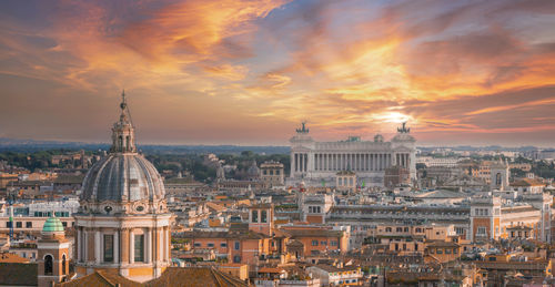 Buildings in city against sky during sunset