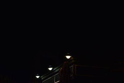 Low angle view of illuminated street light against sky at night