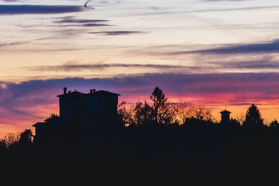 Silhouette buildings against sky at sunset