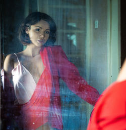 Portrait of woman with reflection on window