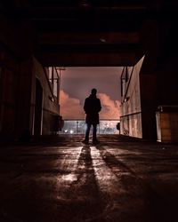 Rear view of silhouette man standing in corridor