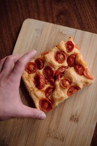 Close-up of hand holding pizza