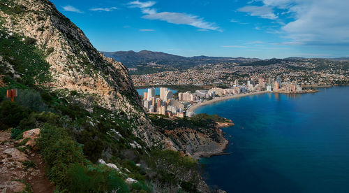 Scenic view of sea by buildings against sky