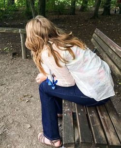Girl standing on bench in park