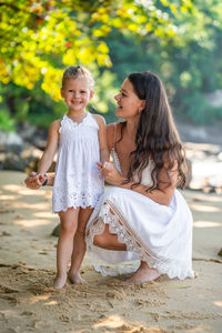 Portrait of smiling young woman standing at beach